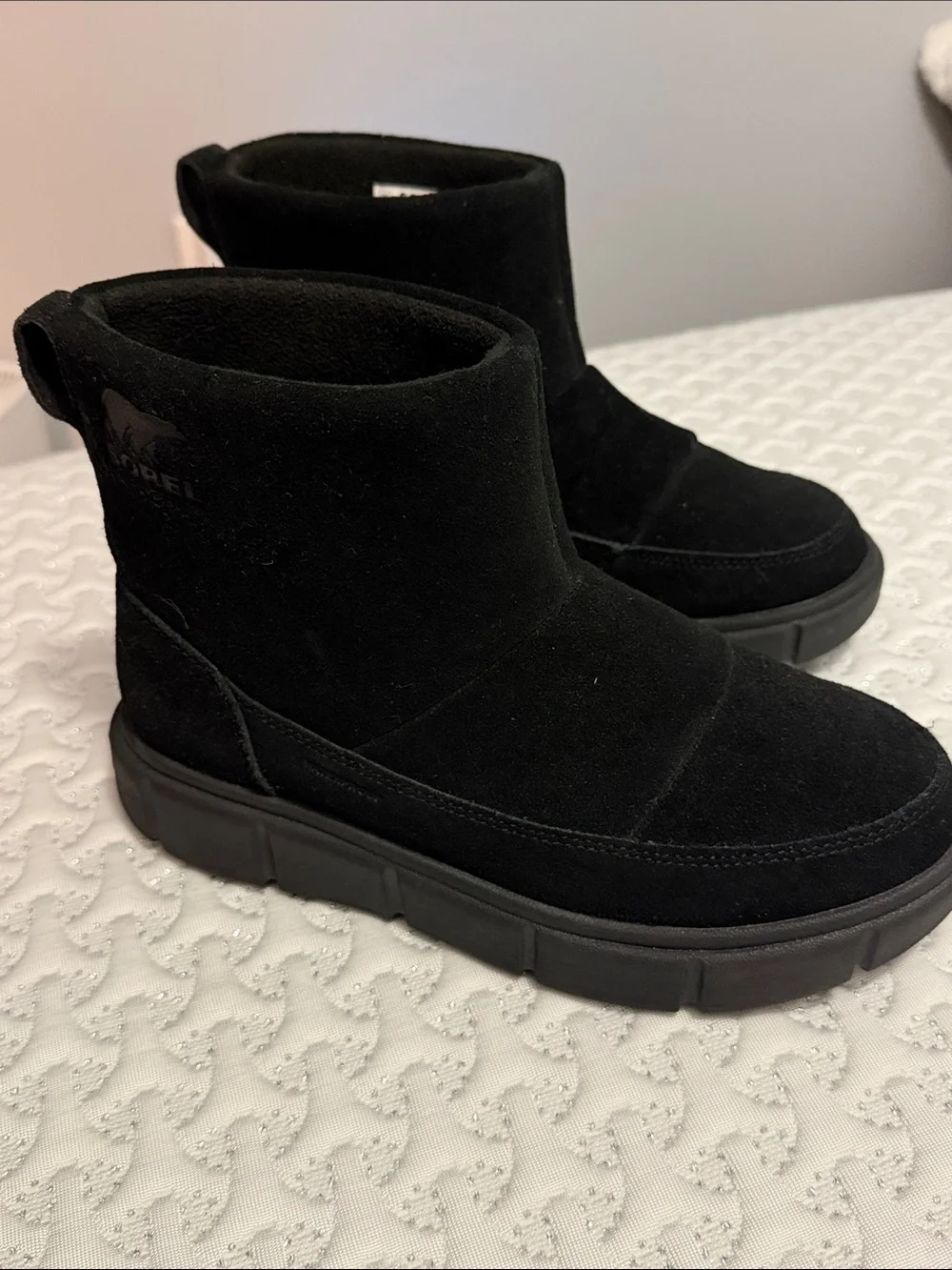The image shows a pair of black SOREL Women's Explorer III Slip-On waterproof